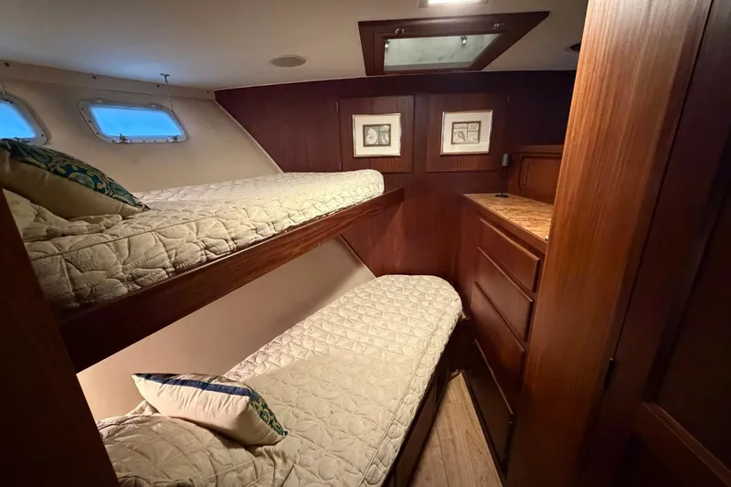 Slide: The Image of 1987 Hatteras 54 Motor Yacht cabin with bunk beds and wooden interior. - 71
