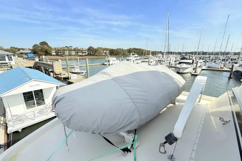 Slide: The Image of 1987 Hatteras 54 Motor Yacht docked at marina with covered equipment on deck. - 87