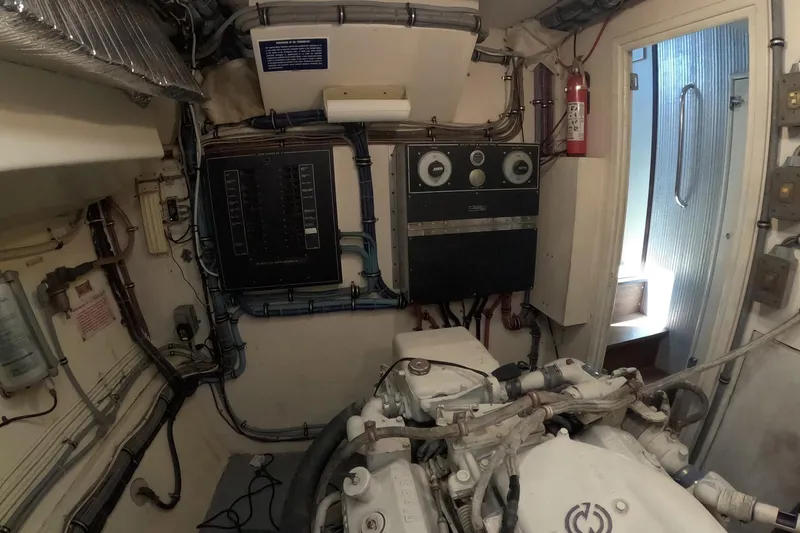Slide: The Image of Engine room of a 1987 Hatteras 54 Motor Yacht, featuring control panels and machinery. - 91
