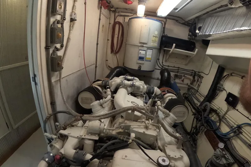 Slide: The Image of Engine room of a 1987 Hatteras 54 Motor Yacht, showcasing mechanical components and wiring. - 92