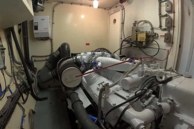 Slide: The Image of Engine room of a 1987 Hatteras 54 Motor Yacht, showcasing mechanical components and wiring. - 94