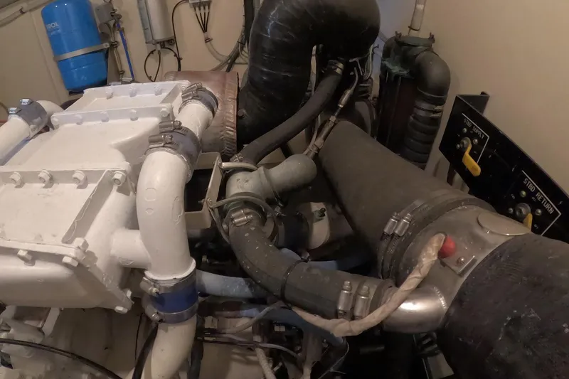 Slide: The Image of Engine room of 1987 Hatteras 54 Motor Yacht with visible pipes and control panel. - 97