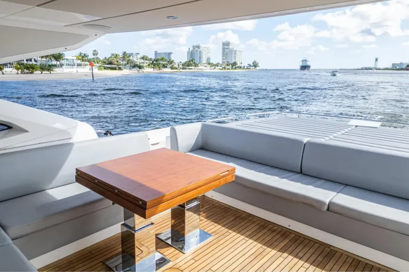 Slide: The Image of Luxury Sunseeker Predator 74 yacht interior with ocean view, featuring sleek seating and wooden table. - 8