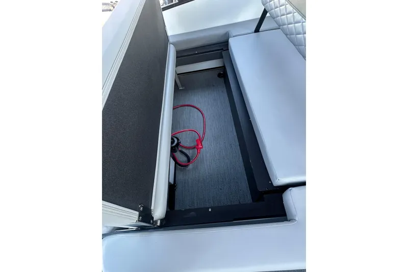 Slide: The Image of Open storage compartment in 2026 Godfrey Monaco 235 SFL boat with visible red cable. - 20