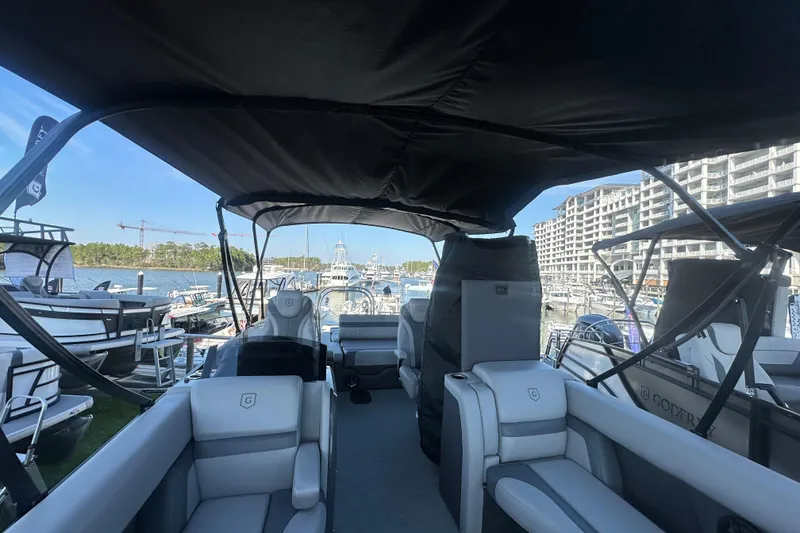 Slide: The Image of 2026 Godfrey Monaco 235 SFL pontoon boat interior at marina, featuring luxurious seating. - 26