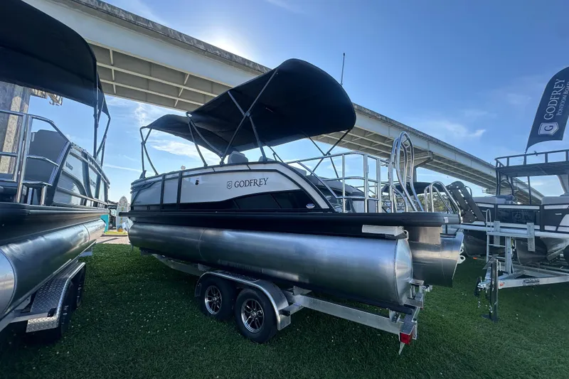 Slide: The Image of 2026 Godfrey Monaco 235 SFL pontoon boat displayed outdoors under a bridge. - 5