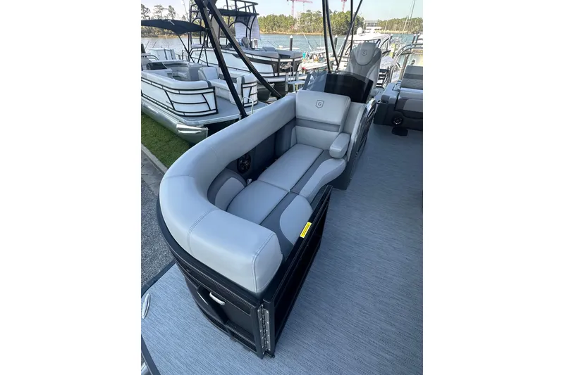 Slide: The Image of 2026 Godfrey Monaco 235 SFL pontoon boat with luxurious seating at a marina. - 6