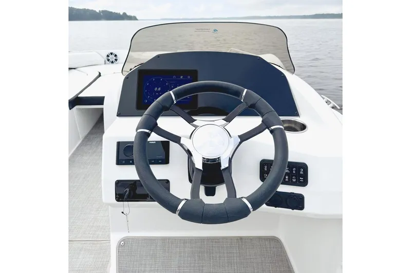 Slide: The Image of Manufacturer Provided Image: Steering wheel and dashboard of 2026 Stingray 212 SC boat on calm water. - 15