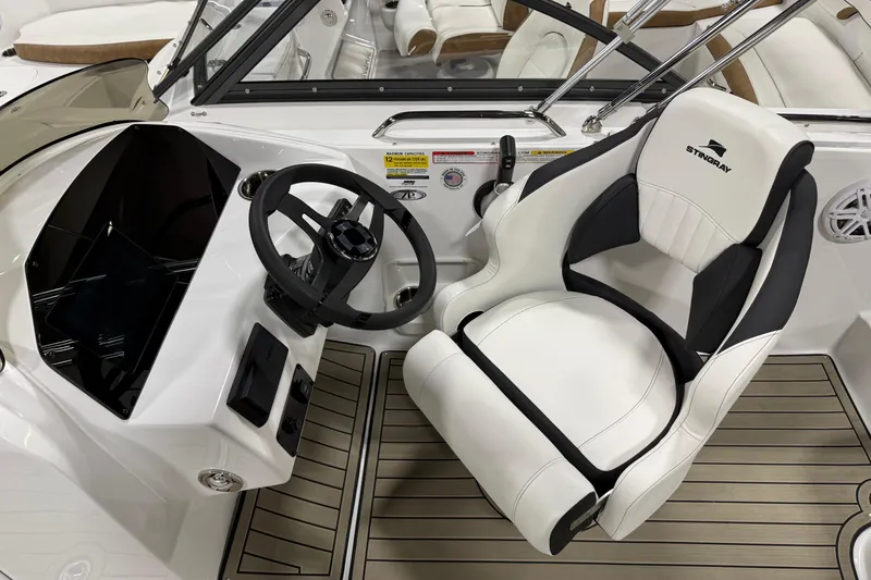 Slide: The Image of 2026 Stingray 212 SC boat interior with steering wheel and white captain's chair. - 4