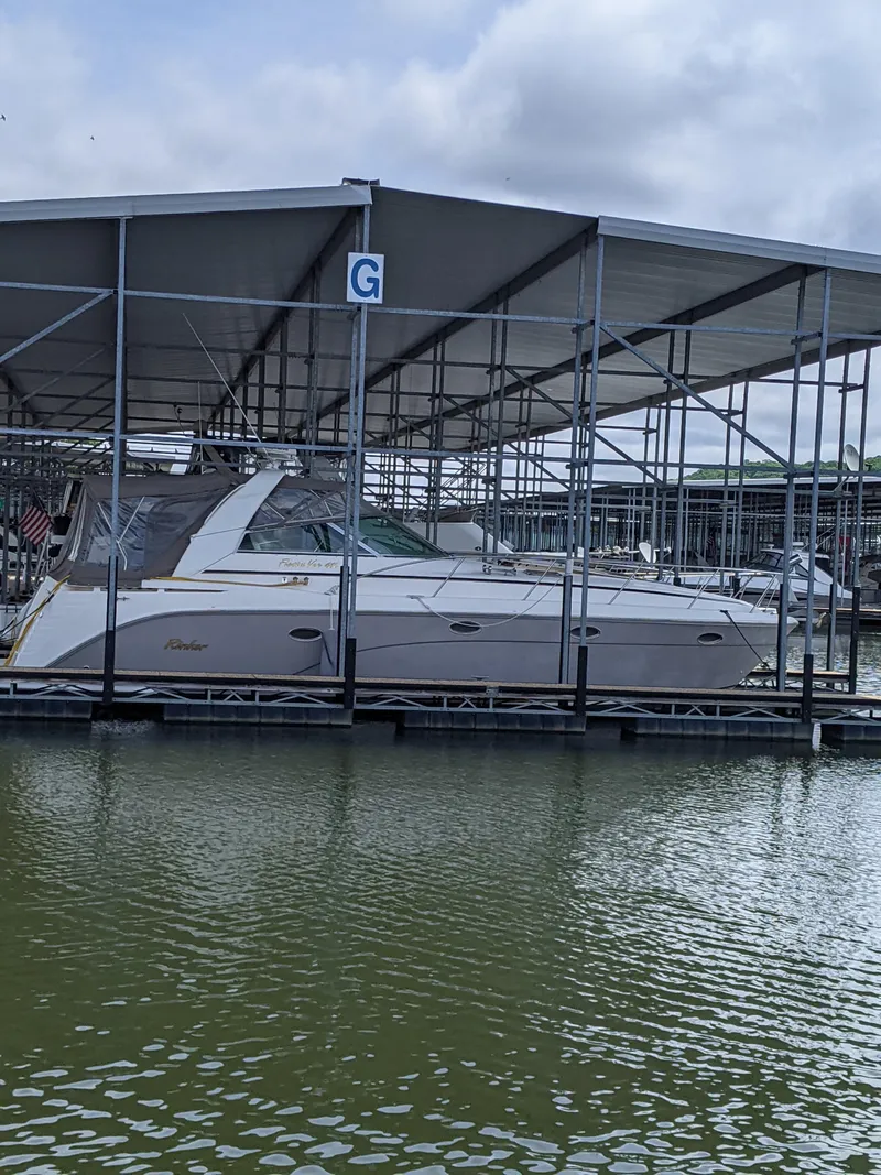The Image of 2004 Rinker Fiesta Vee 410 docked under covered marina. - 0