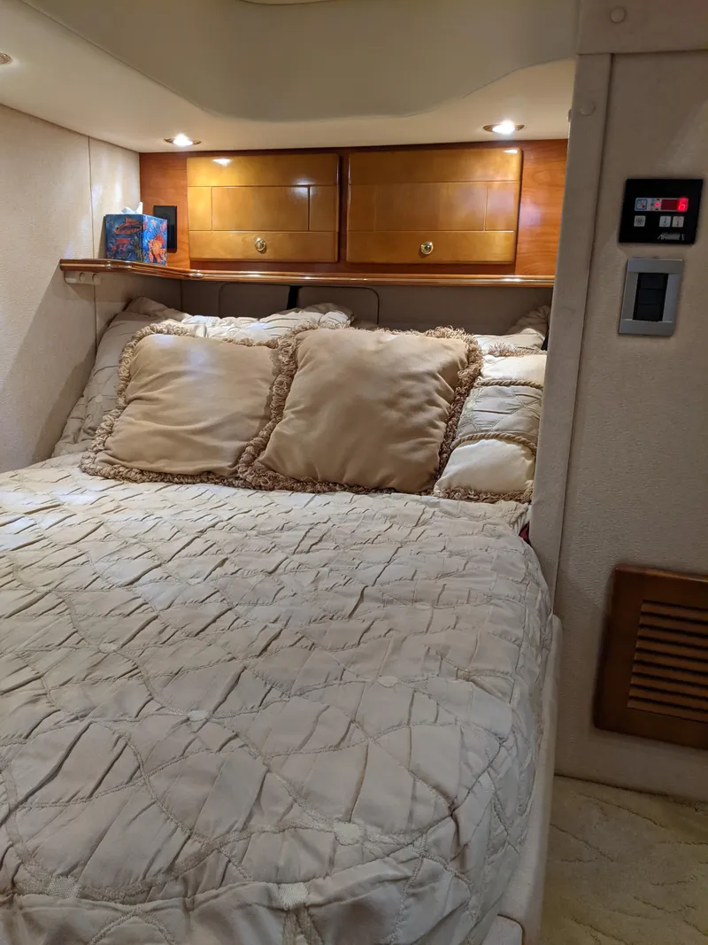 Slide: The Image of 2004 Rinker Fiesta Vee 410 cabin interior with cozy bed and wooden cabinets. - 19