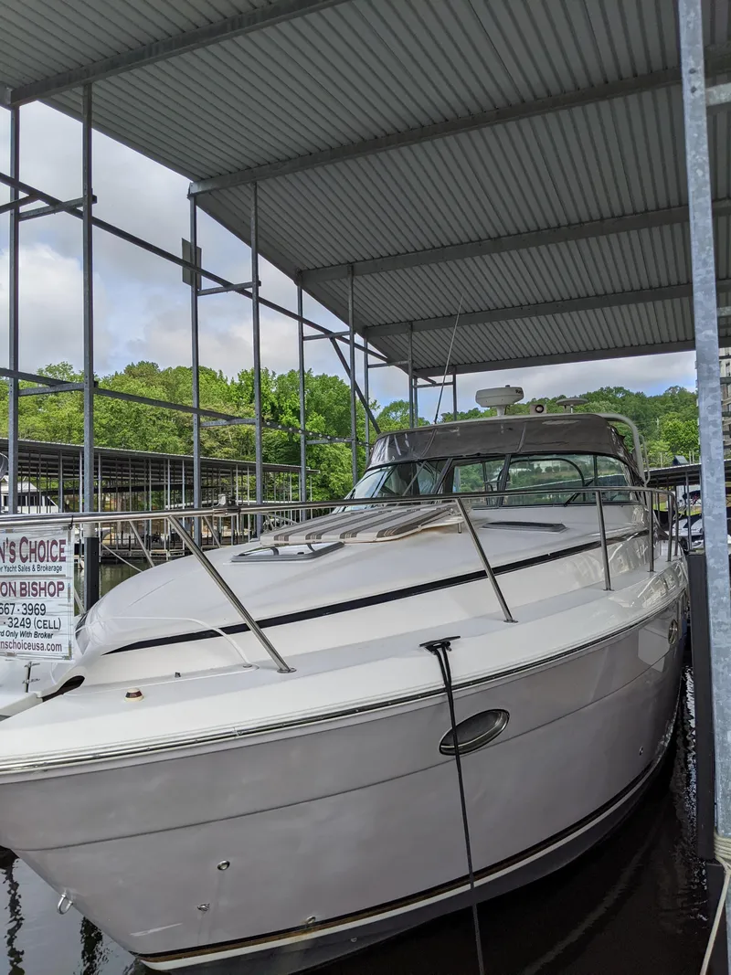 Slide: The Image of 2004 Rinker Fiesta Vee 410 boat docked under a covered marina. - 2