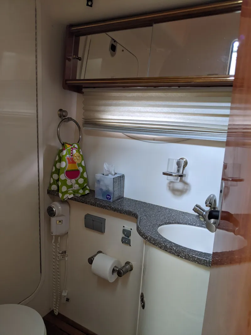 Slide: The Image of 2004 Rinker Fiesta Vee 410 bathroom with sink, mirror, and storage. - 22