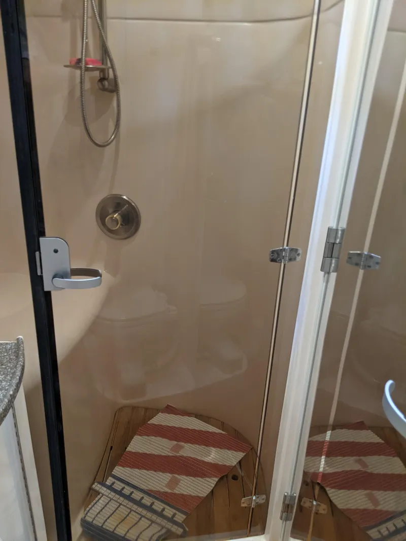 Slide: The Image of Shower area in 2004 Rinker Fiesta Vee 410 boat with glass door and striped mat. - 23
