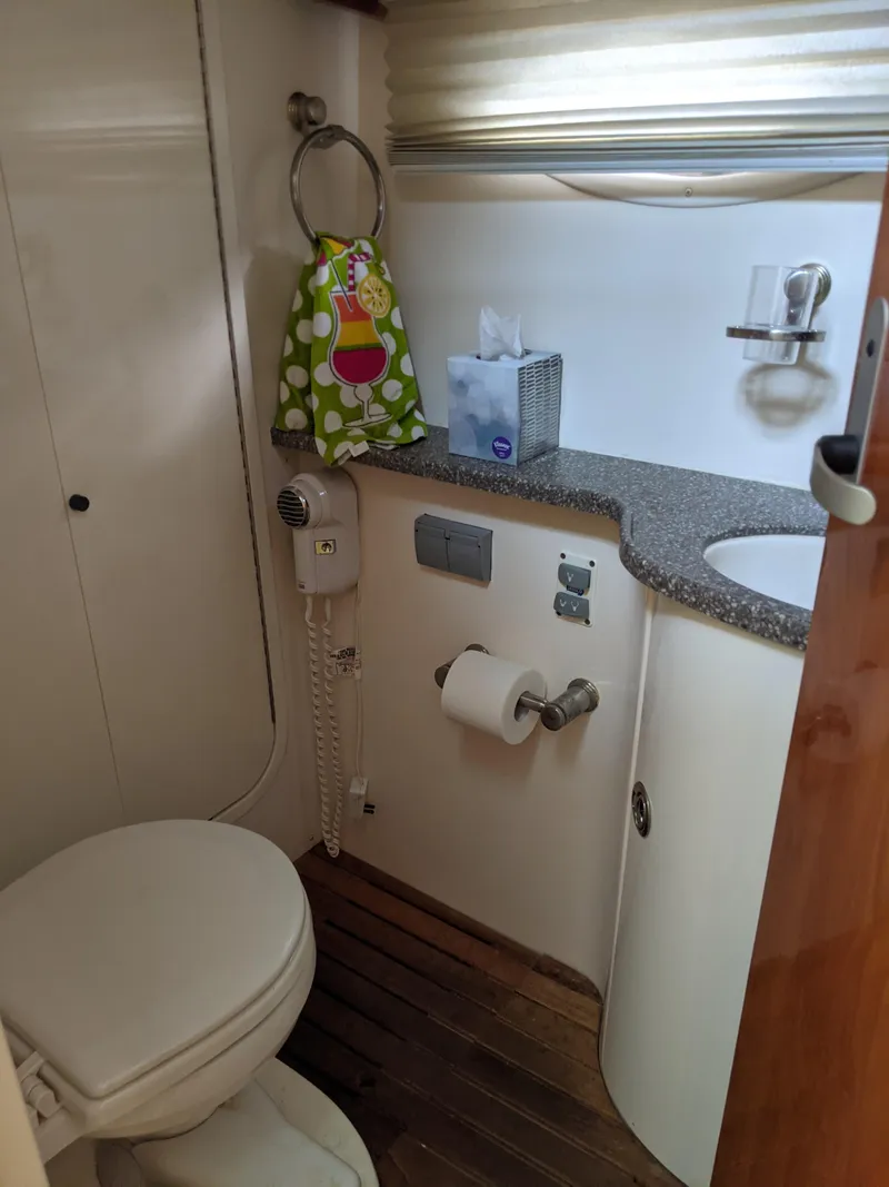 Slide: The Image of 2004 Rinker Fiesta Vee 410 bathroom with toilet, sink, and wooden floor. - 24