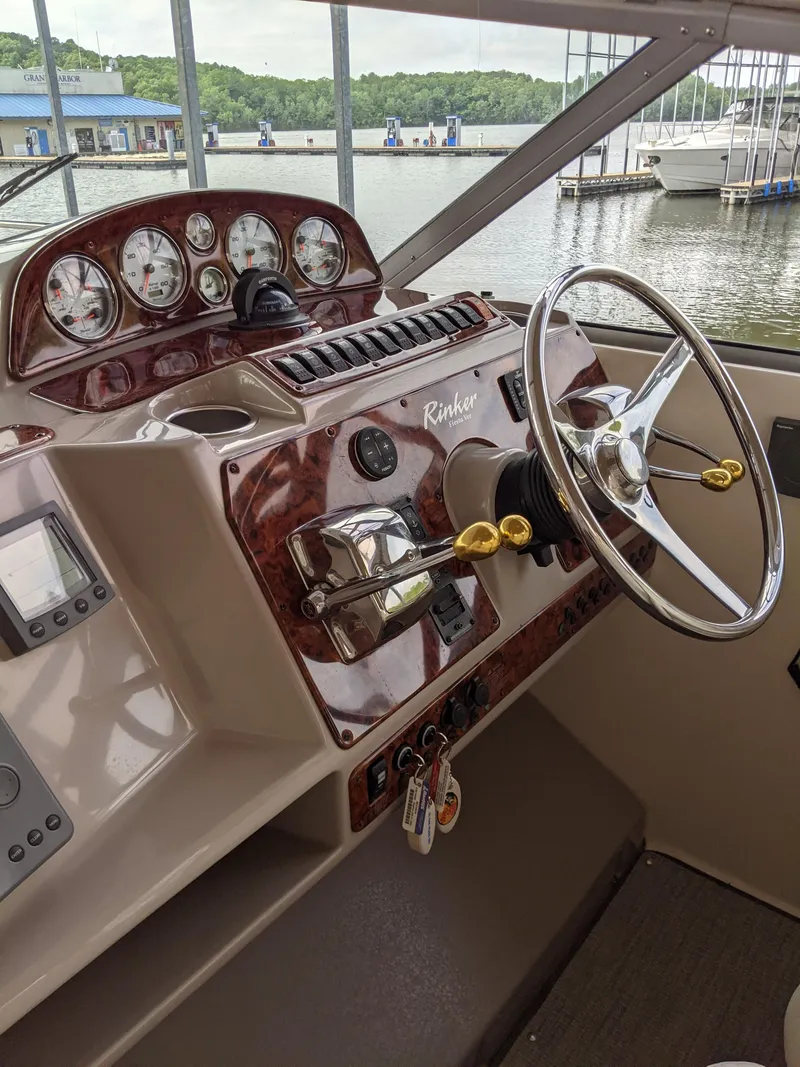 Slide: The Image of 2004 Rinker Fiesta Vee 410 boat dashboard with steering wheel and gauges. - 41