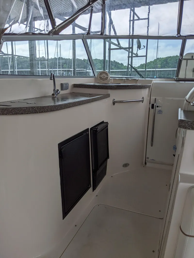 Slide: The Image of 2004 Rinker Fiesta Vee 410 boat interior with kitchenette and windows. - 43