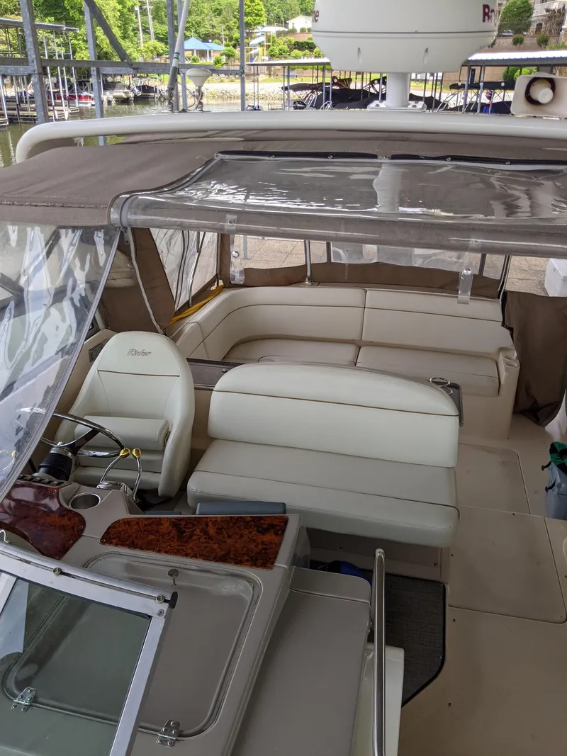 Slide: The Image of 2004 Rinker Fiesta Vee 410 boat interior with seating and helm under canopy. - 9