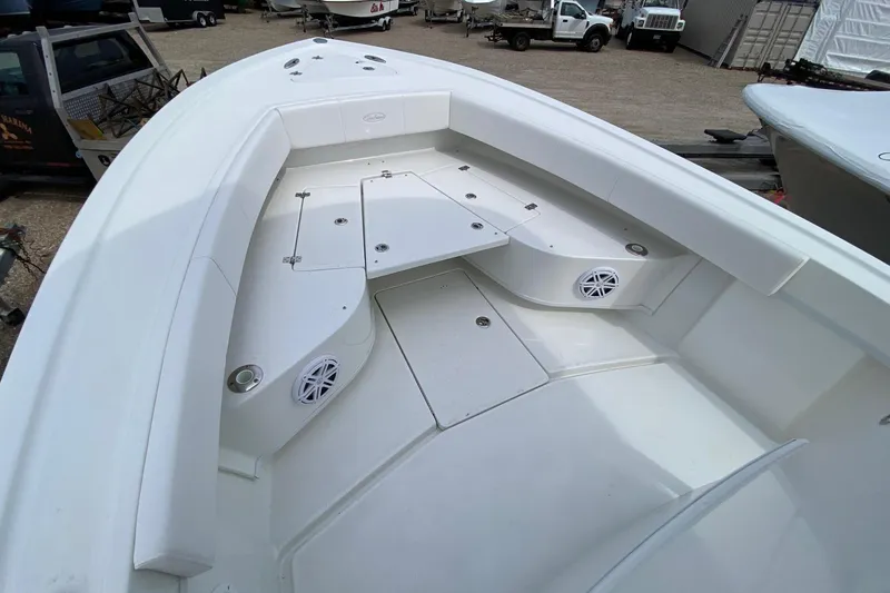 Slide: The Image of 2026 Pair Customs 24 Center Console DV Offshore boat interior with white seating and storage compartments. - 11