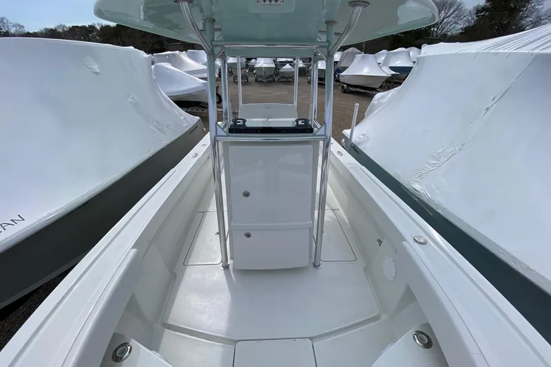 Slide: The Image of 2026 Pair Customs 24 Center Console DV Offshore boat, docked with protective covers. - 12