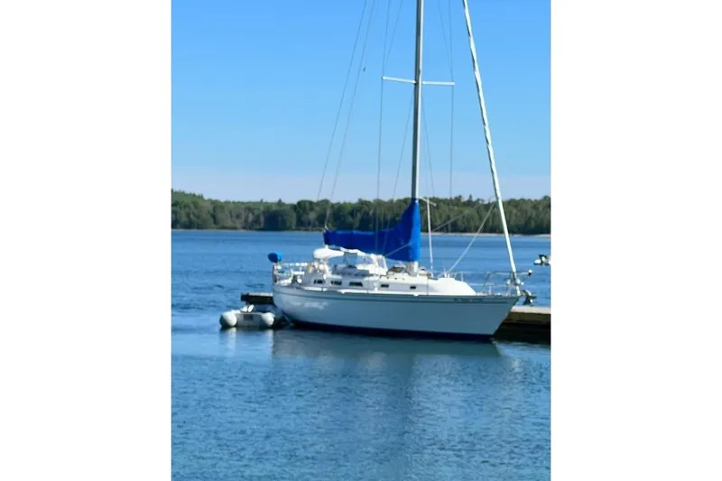 The Image of 1985 Pearson Yachts 36-2 sailboat docked on calm blue water. - 1