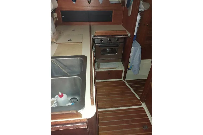 Slide: The Image of 1985 Pearson Yachts 36-2 galley with stove, sink, and wooden flooring. - 10