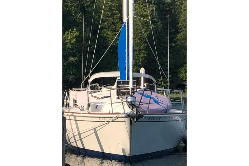 Slide: The Image of 1985 Pearson Yachts 36-2 sailboat docked in a serene wooded area. - 4