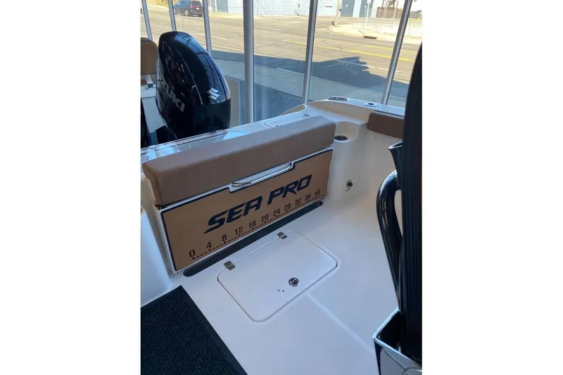 Slide: The Image of 2024 Sea Pro 259 DLX boat interior with Suzuki engine, featuring seating and storage. - 4