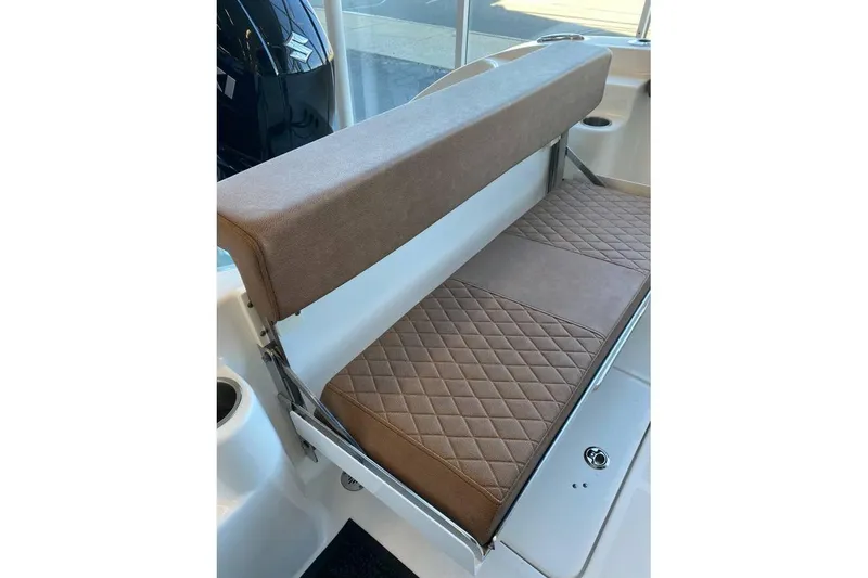 Slide: The Image of 2024 Sea Pro 259 DLX boat with brown cushioned seating and diamond pattern design. - 5