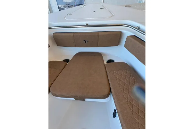 Slide: The Image of 2024 Sea Pro 259 DLX boat interior with brown cushioned seating. - 6