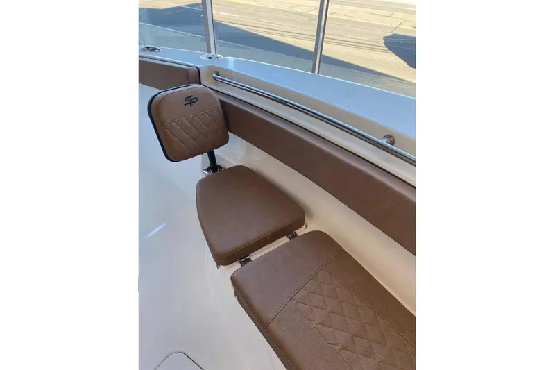 Slide: The Image of 2024 Sea Pro 259 DLX boat seating with brown cushions and SP logo. - 7