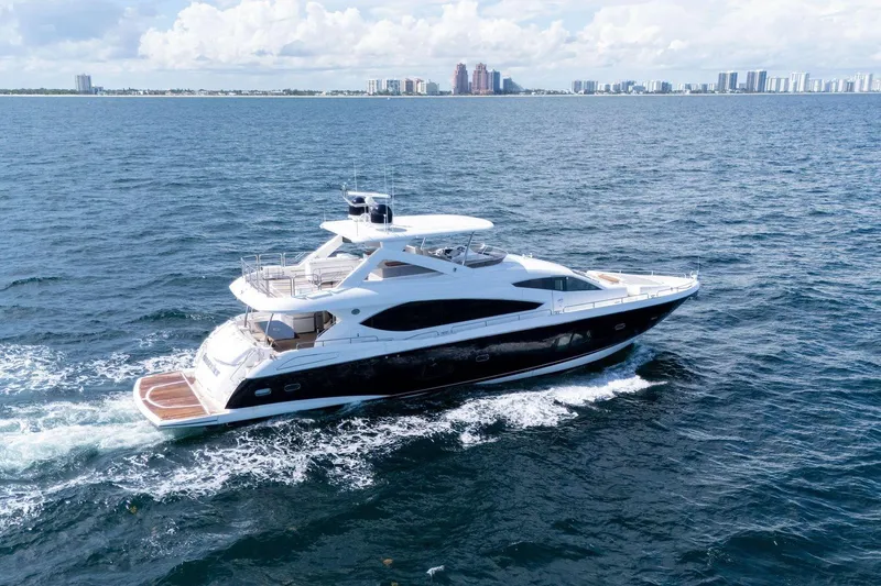 The Image of Luxurious 2012 Sunseeker 88 Yacht cruising on open water with city skyline backdrop. - 1
