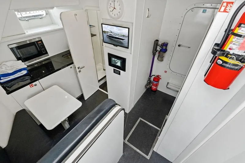 Slide: The Image of Interior of 2012 Sunseeker 88 Yacht featuring kitchenette, seating area, and safety equipment. - 100