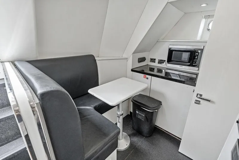 Slide: The Image of Compact dining area and kitchenette in 2012 Sunseeker 88 Yacht, featuring a microwave and seating. - 101