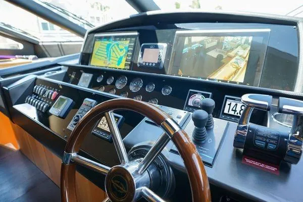 Slide: The Image of Control panel of a 2012 Sunseeker 88 Yacht with navigation screens and steering wheel. - 25