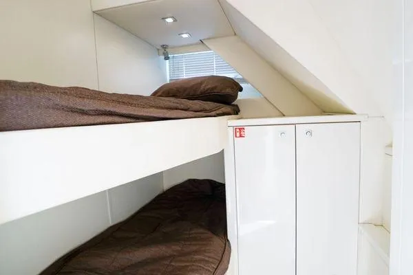 Slide: The Image of Bunk beds in 2012 Sunseeker 88 Yacht cabin with brown bedding and white cabinetry. - 45