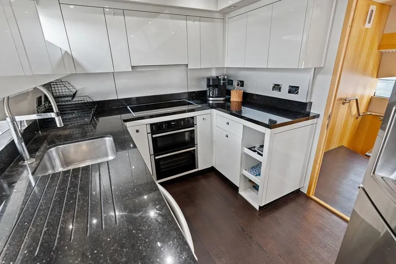 Slide: The Image of Modern kitchen interior on a 2012 Sunseeker 88 Yacht with sleek black countertops. - 60