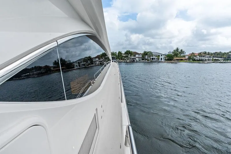 Slide: The Image of Side view of a 2012 Sunseeker 88 Yacht cruising near waterfront homes. - 67