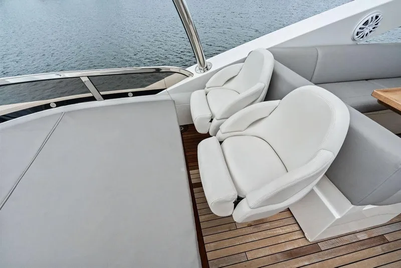 Slide: The Image of Luxurious seating on 2012 Sunseeker 88 Yacht, featuring elegant white chairs and wooden deck. - 78