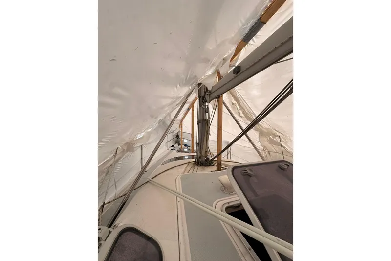 Slide: The Image of 1997 Hunter 340 sailboat deck under protective cover, showing rigging and hatches. - 12
