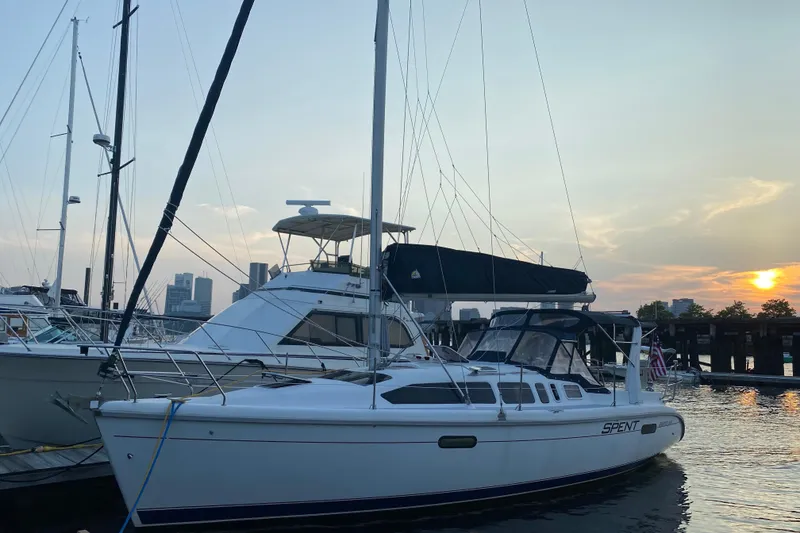 Slide: The Image of Sailboat docked at sunset, Hunter 340 model, 1997, with city skyline in background. - 2