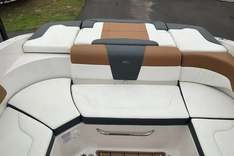 Slide: The Image of 2023 Chaparral 23 SSi boat interior with white, brown, and gray cushioned seating. - 11