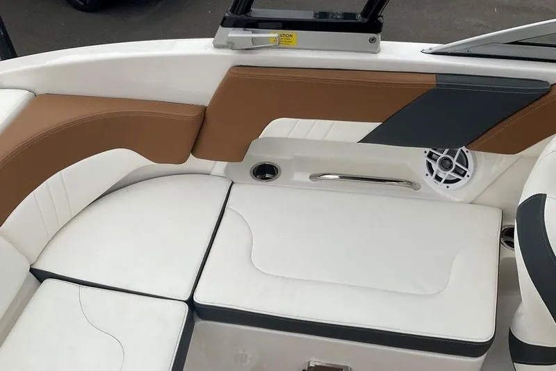 Slide: The Image of 2023 Chaparral 23 SSi boat interior with white and brown seating, speaker, and handle. - 16
