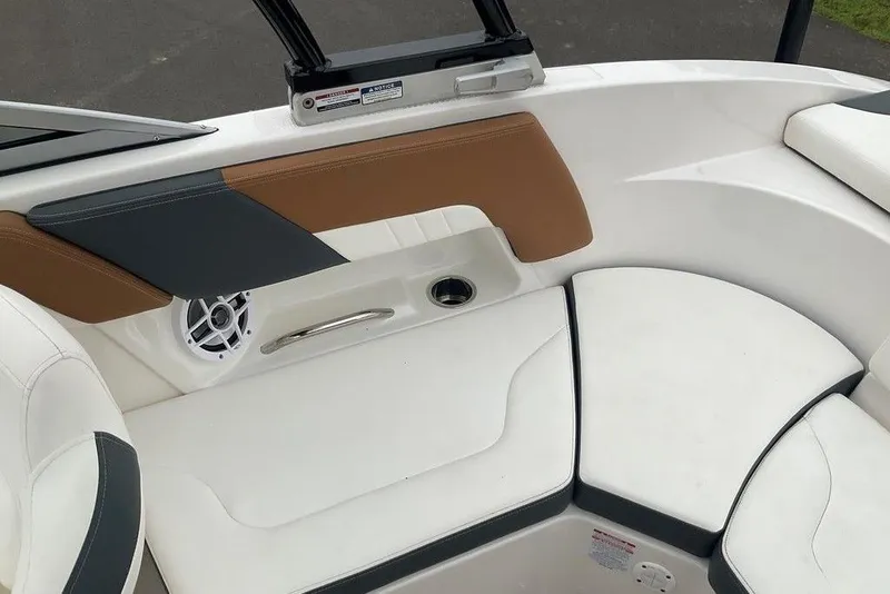 Slide: The Image of 2023 Chaparral 23 SSi boat interior with white and tan seating, speaker, and handle. - 17
