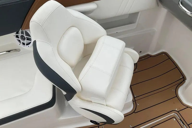 Slide: The Image of 2023 Chaparral 23 SSi boat interior with white cushioned seat and brown flooring. - 21