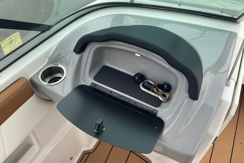 Slide: The Image of 2023 Chaparral 23 SSi boat interior with storage compartment and cup holder. - 23