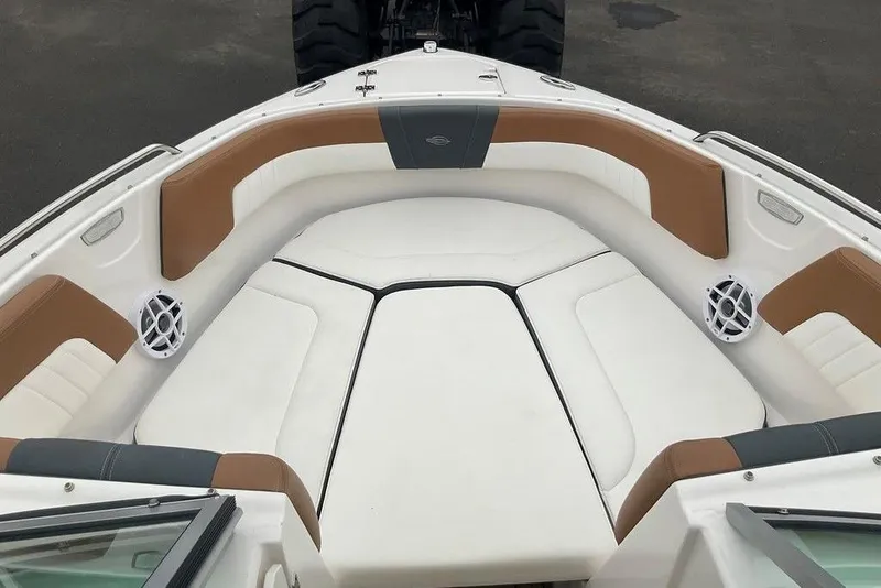 Slide: The Image of 2023 Chaparral 23 SSi boat interior with white and brown seating, featuring speakers. - 24