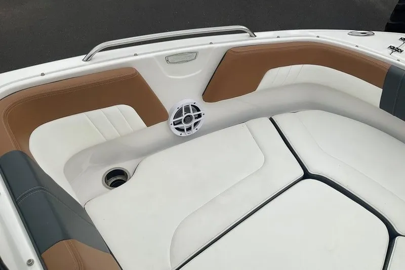 Slide: The Image of 2023 Chaparral 23 SSi boat interior with white and tan seating, speaker, and cup holder. - 25