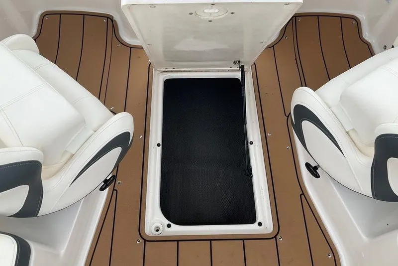 Slide: The Image of 2023 Chaparral 23 SSi boat interior with open storage compartment and white seating. - 28
