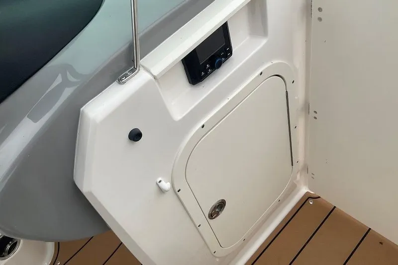 Slide: The Image of 2023 Chaparral 23 SSi boat interior with control panel and storage compartment. - 29